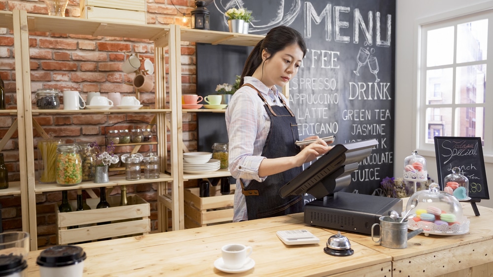 Waitress behind a cashier at a store