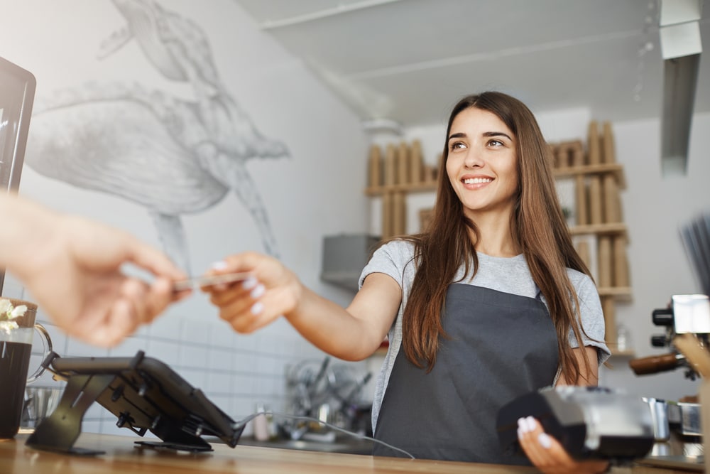 Female worker processing credit card at a small business