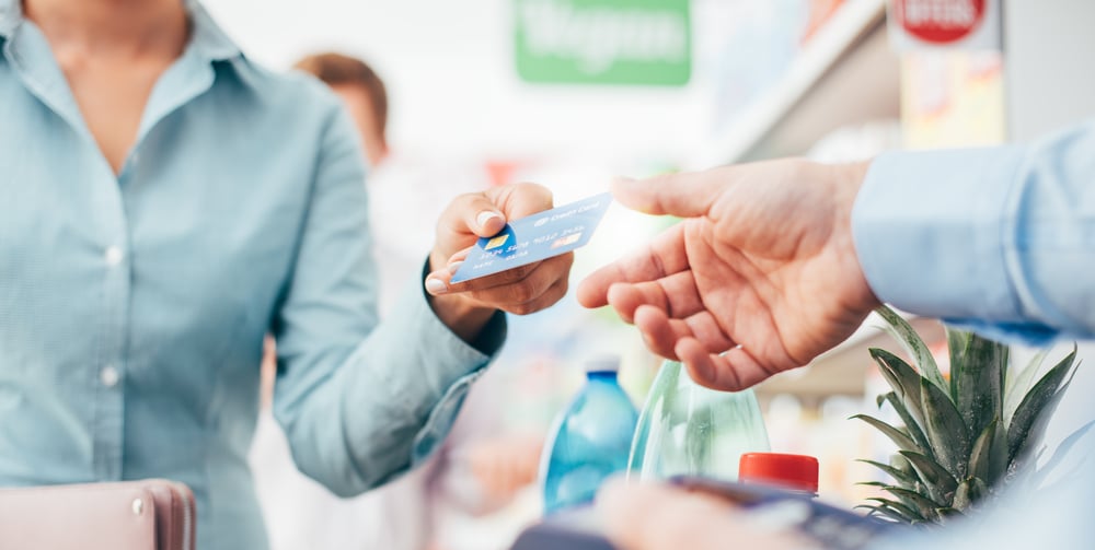 Woman paying with credit card at business that uses a local merchant service provider.