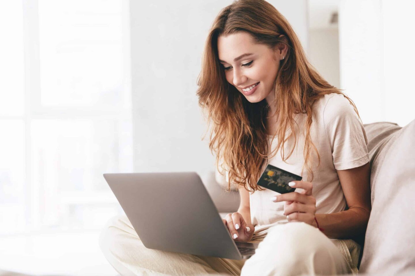 woman paying for something with her credit card on her laptop